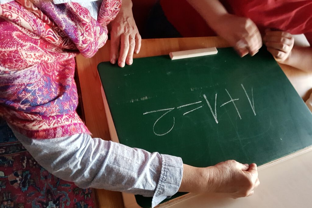 Kind schreibt auf einer Schultafel