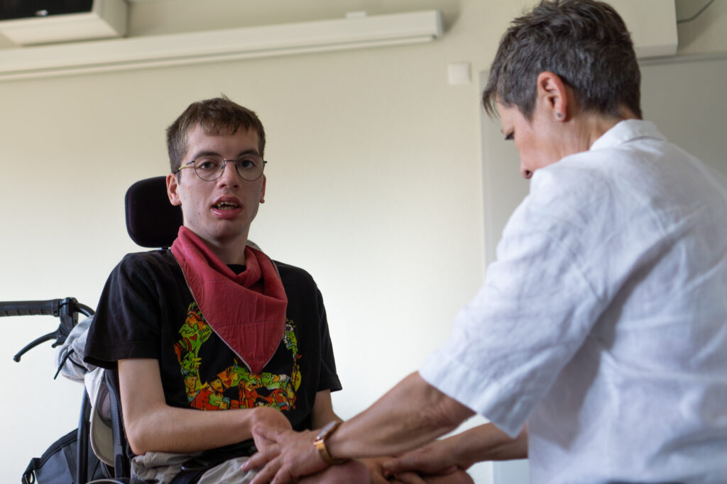 Ein Mann im Rollstuhl erhält therapeutische Hilfe